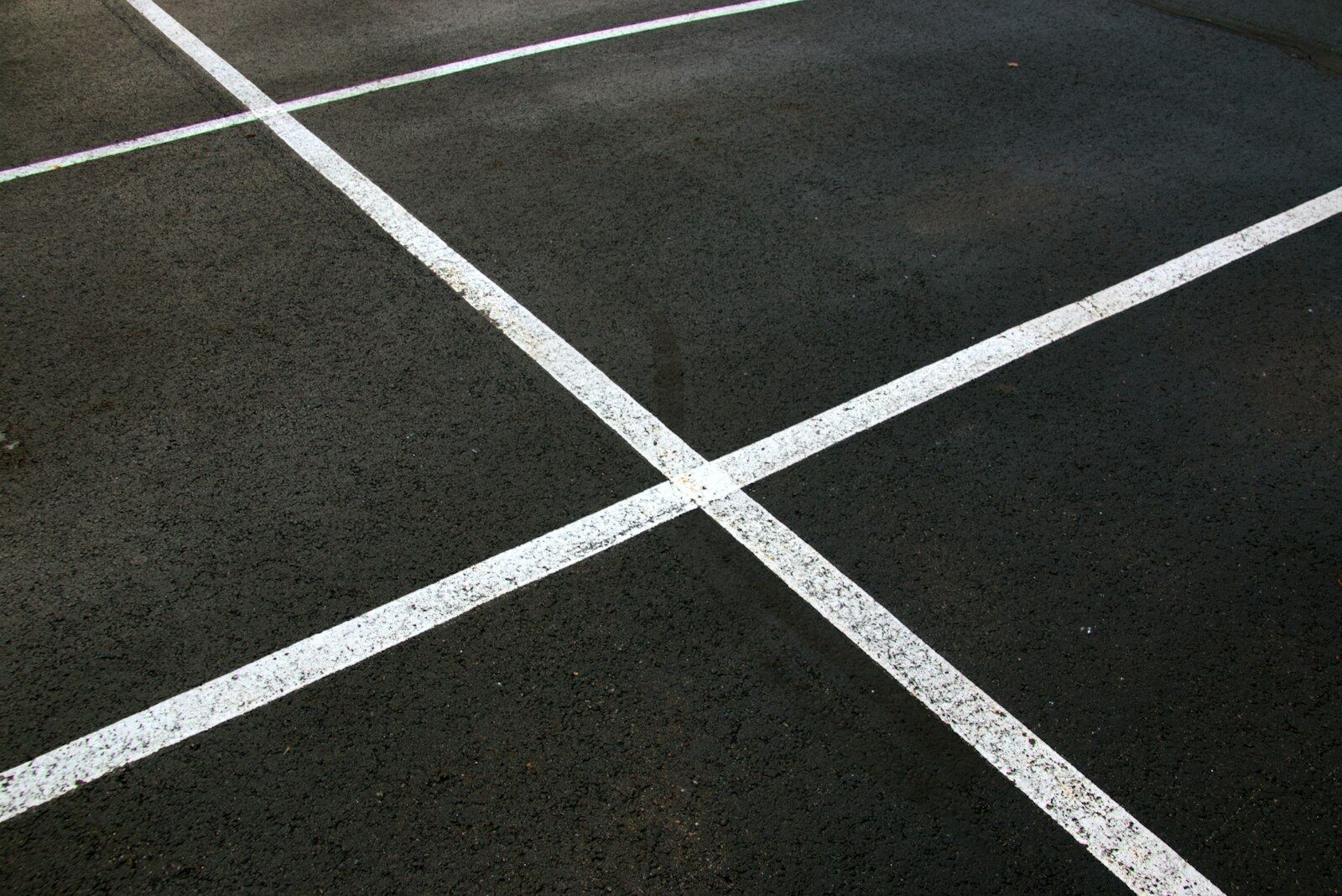 Crisp white parking lot line striping on dark asphalt
